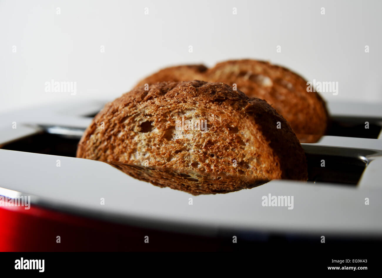 Electrical toaster in kitchen with cooked toast made from brown bread