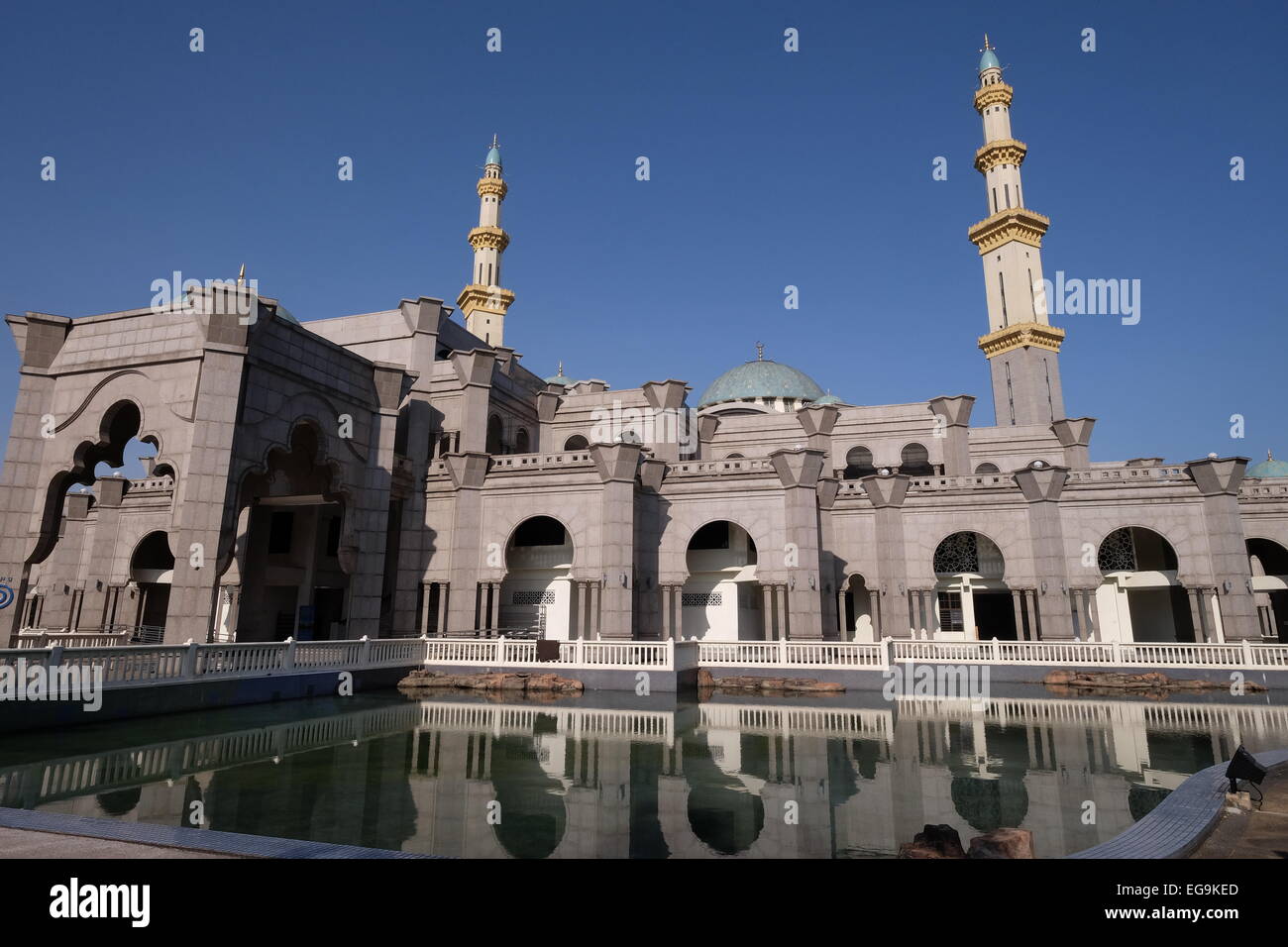 Malaysia, Kuala Lumpur, View of The Federal Territory Mosque against blue sky, pond in foreground Stock Photo