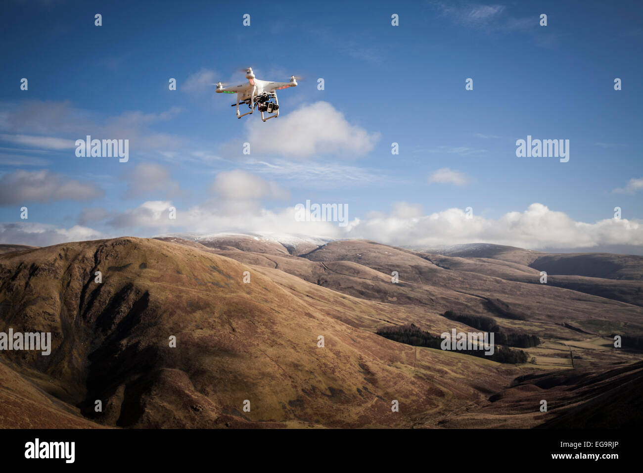 A Drone hovers above a scenic backdrop on a sunny day Stock Photo