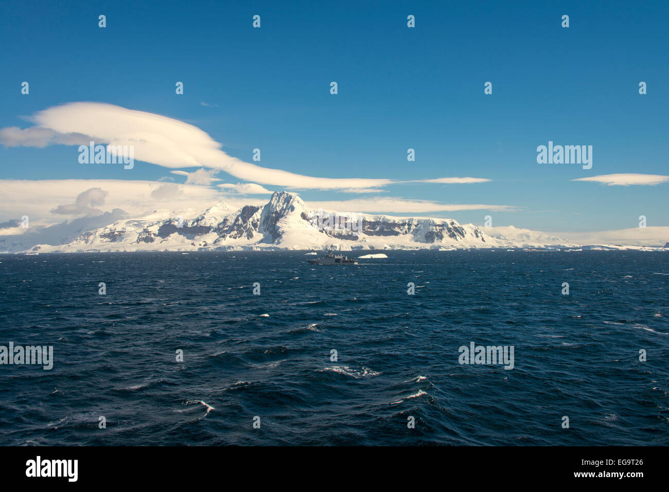 Snow capped mountains of Anvers Island, Dallmann Bay, Antarctica. Ecquadorian patrol vessel no 46 Stock Photo