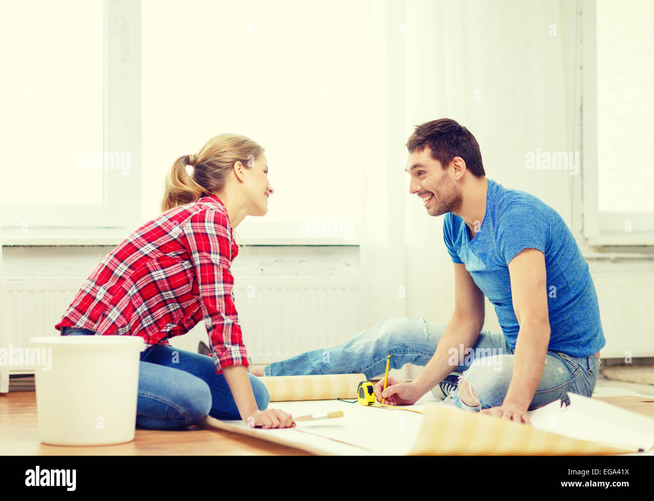 smiling couple measuring wallpaper Stock Photo