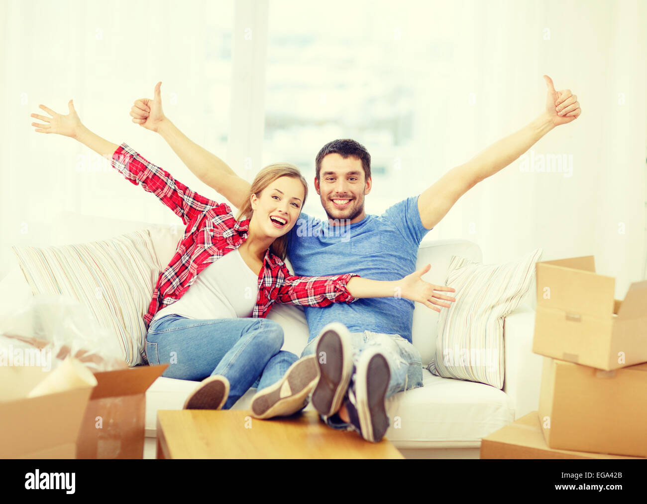 smiling couple relaxing on sofa in new home Stock Photo - Alamy