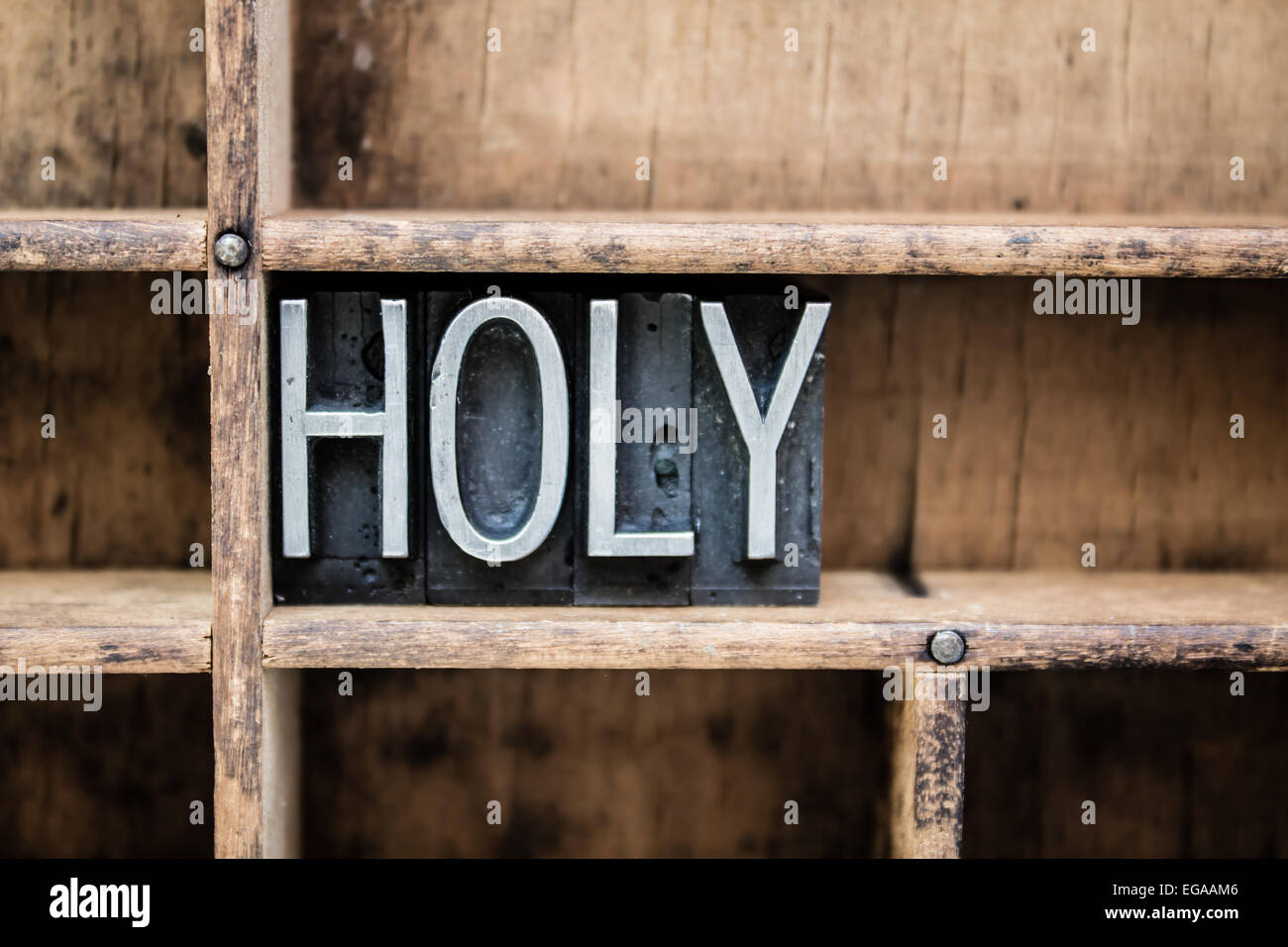 The word 'HOLY' written in vintage metal letterpress type in a wooden drawer with dividers. Stock Photo