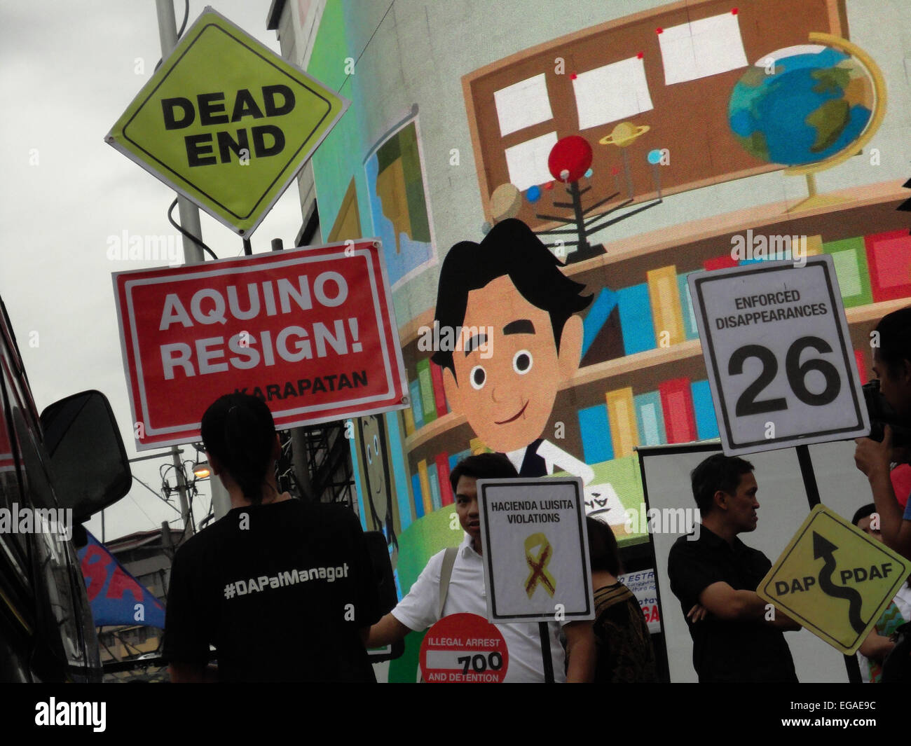An activist carries a dead end sign above a sign calling for President Benigno Aquino III to resign, as she walks along a mock yellow road symbolizing President Aquino's 'Tuwid na Daan' (Straight Path) platform, during a rally at the Plaza Miranda in Quiapo. Activists held a 'People's Hearing' on the Mamasapano incident, where they reported on the findings of a fact-finding mission about the incident, where 44 policemen, 18 Muslim rebels, and 7 civilians were killed in a botched anti-terror operation that reportedly killed Malaysian bombmaker Zulkifli 'Marwan' Abdhir. (Photo by Richard James Stock Photo