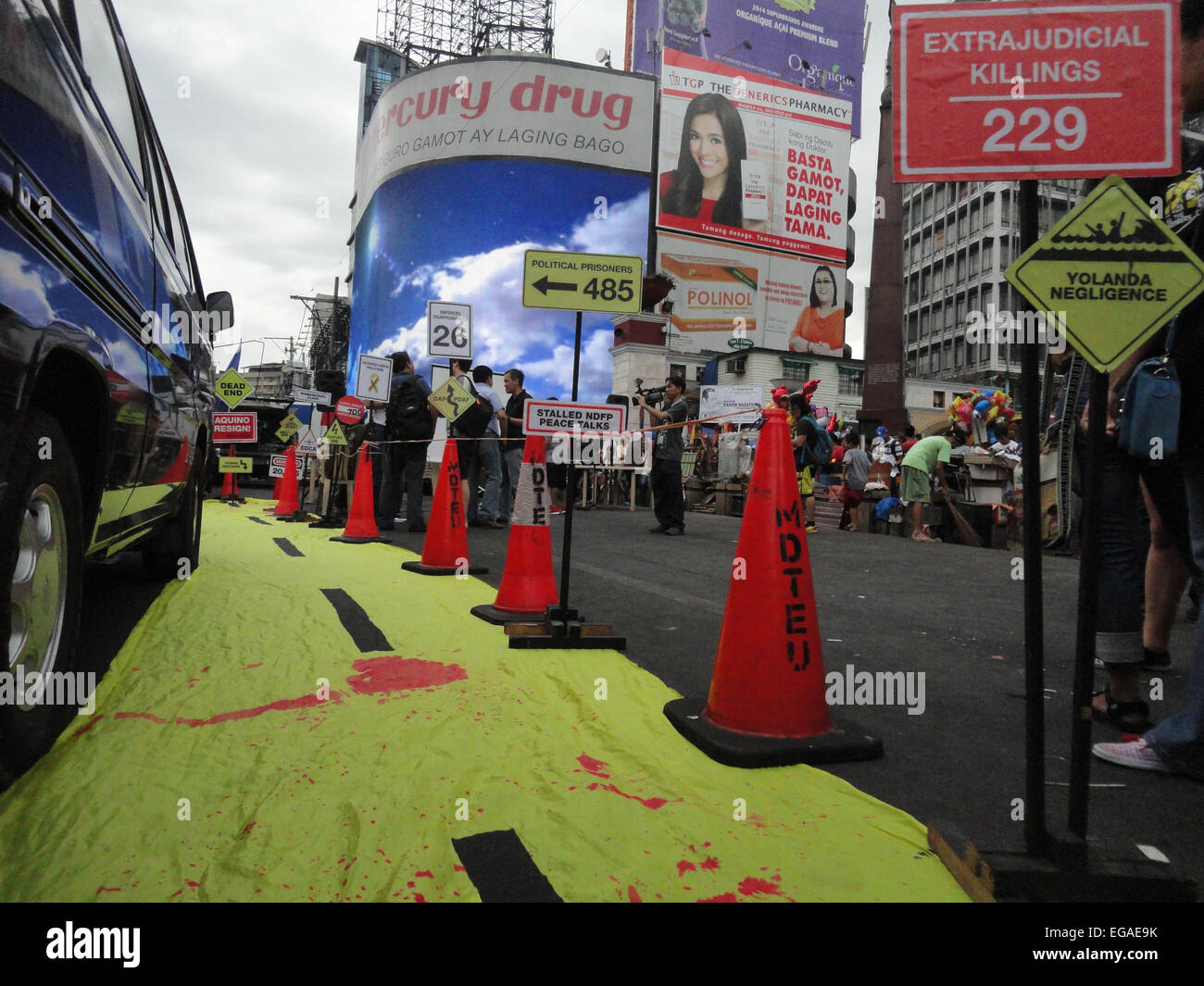 Road signs written with the issues hounding the nation stand alongside a yellow mock road symbolizing President Benigno Aquino III's 'Tuwid na Daan' (Straight Path) platform, during a rally at the Plaza Miranda in Quiapo. Activists held a 'People's Hearing' on the Mamasapano incident, where they reported on the findings of a fact-finding mission about the incident, where 44 policemen, 18 Muslim rebels, and 7 civilians were killed in a botched anti-terror operation that reportedly killed Malaysian bombmaker Zulkifli 'Marwan' Abdhir. © Richard James Mendoza/Pacific Press/Alamy Live News Stock Photo