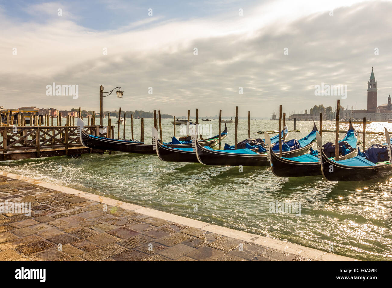 Gondolas moored during high tide and rough weather at St Marks Square in Venice. Stock Photo