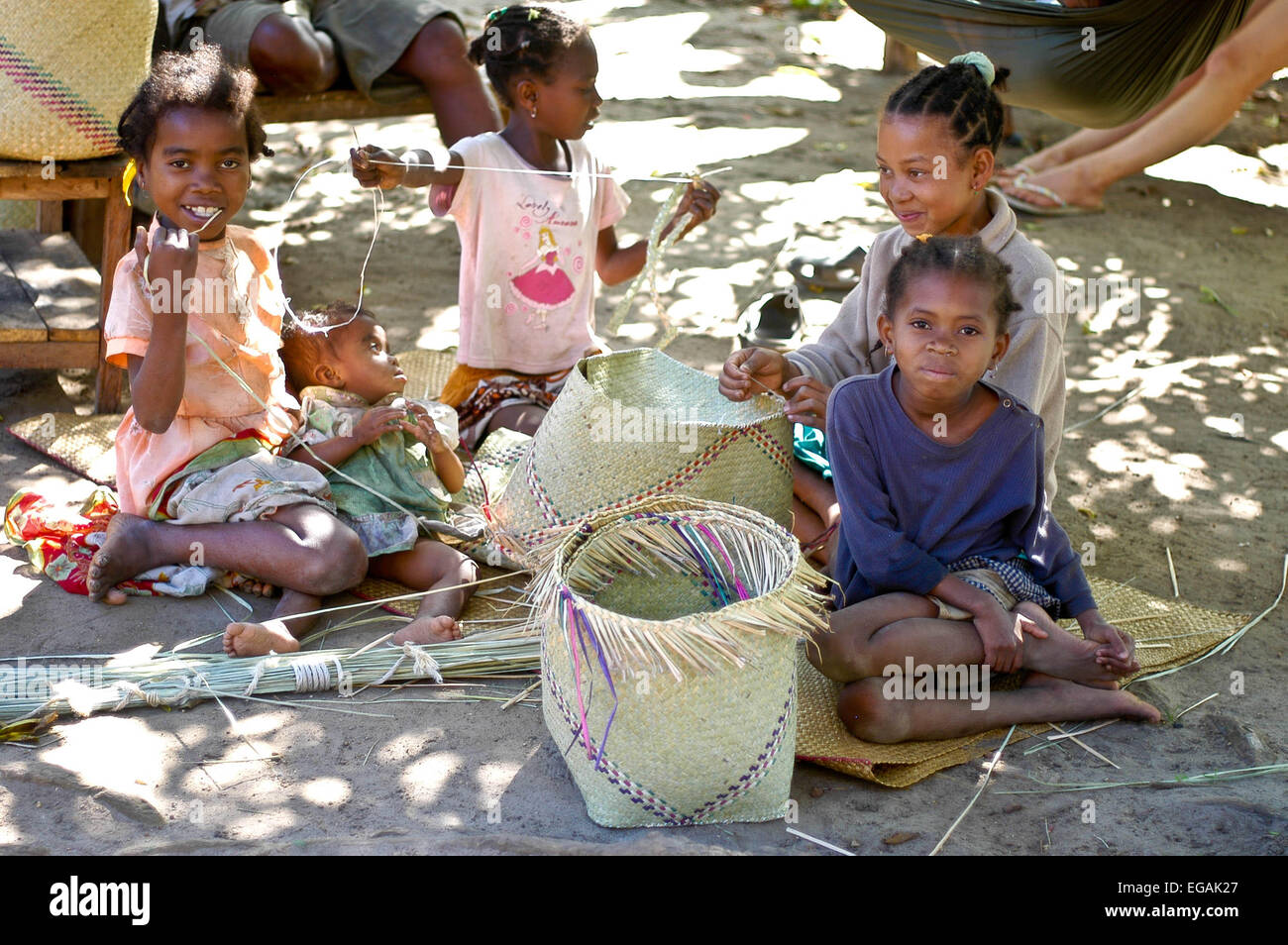 Four  young girls make baskets  for  market, Fort  Dauphin, Madagascar Stock Photo