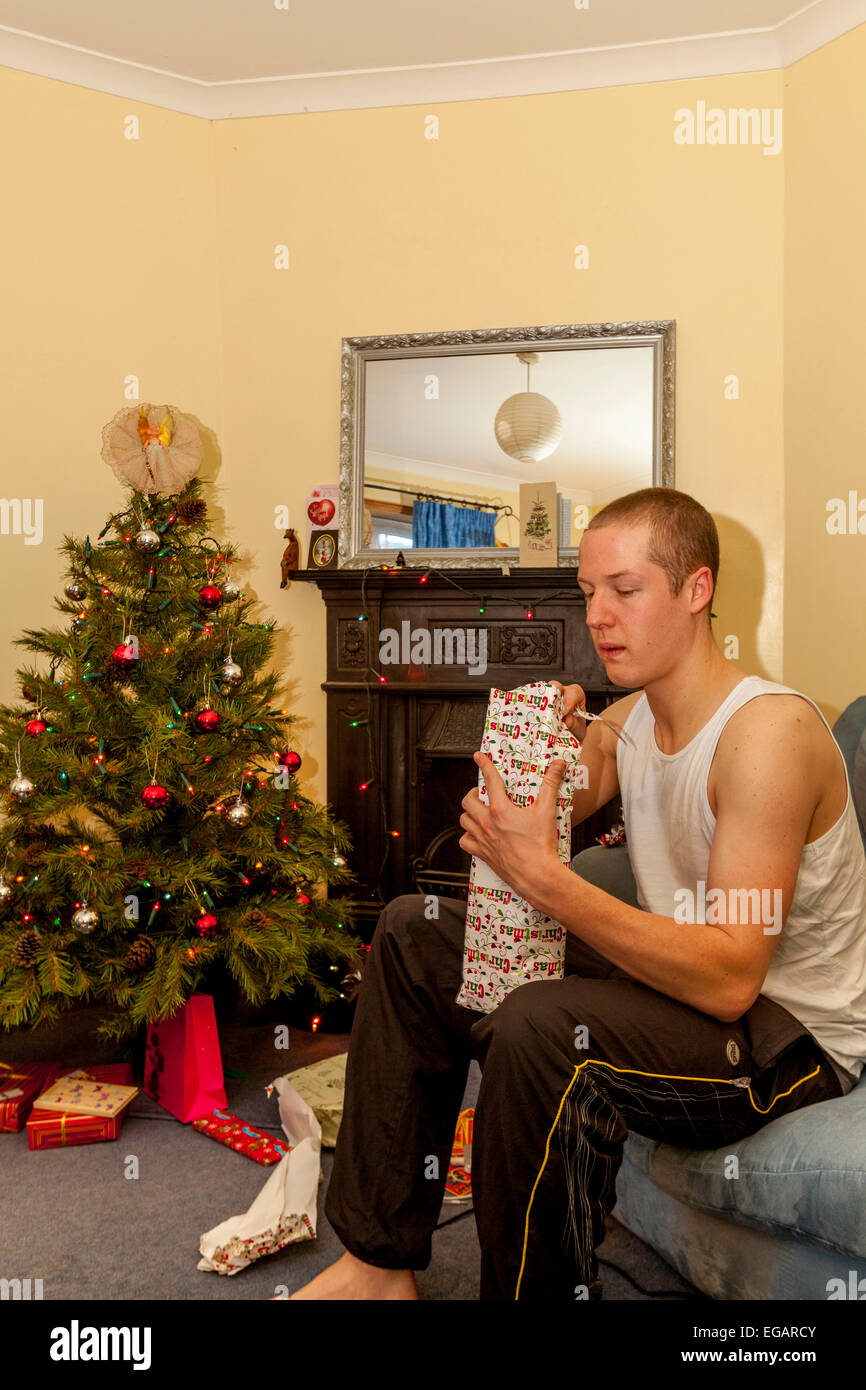 A Young Man Opens Christmas Presents On Christmas Day, Sussex, England Stock Photo