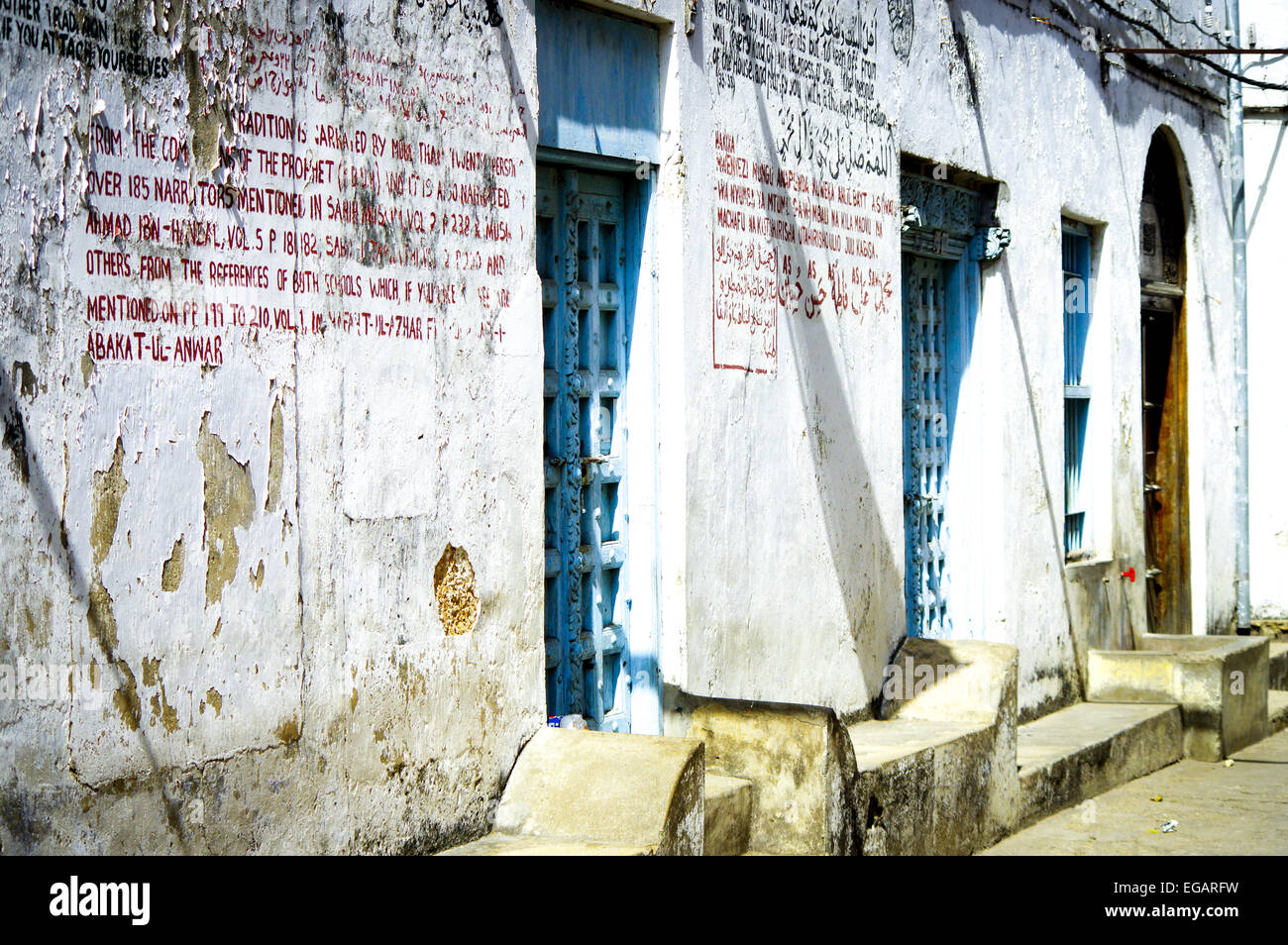 Typical Zanzibari townhouse with baraza benches and ornate doors - Stone Town, Zanzibar Stock Photo