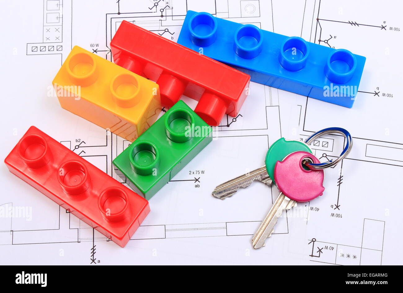 Closeup of home keys and heap of plastic colorful building blocks lying on construction drawing of house, Stock Photo