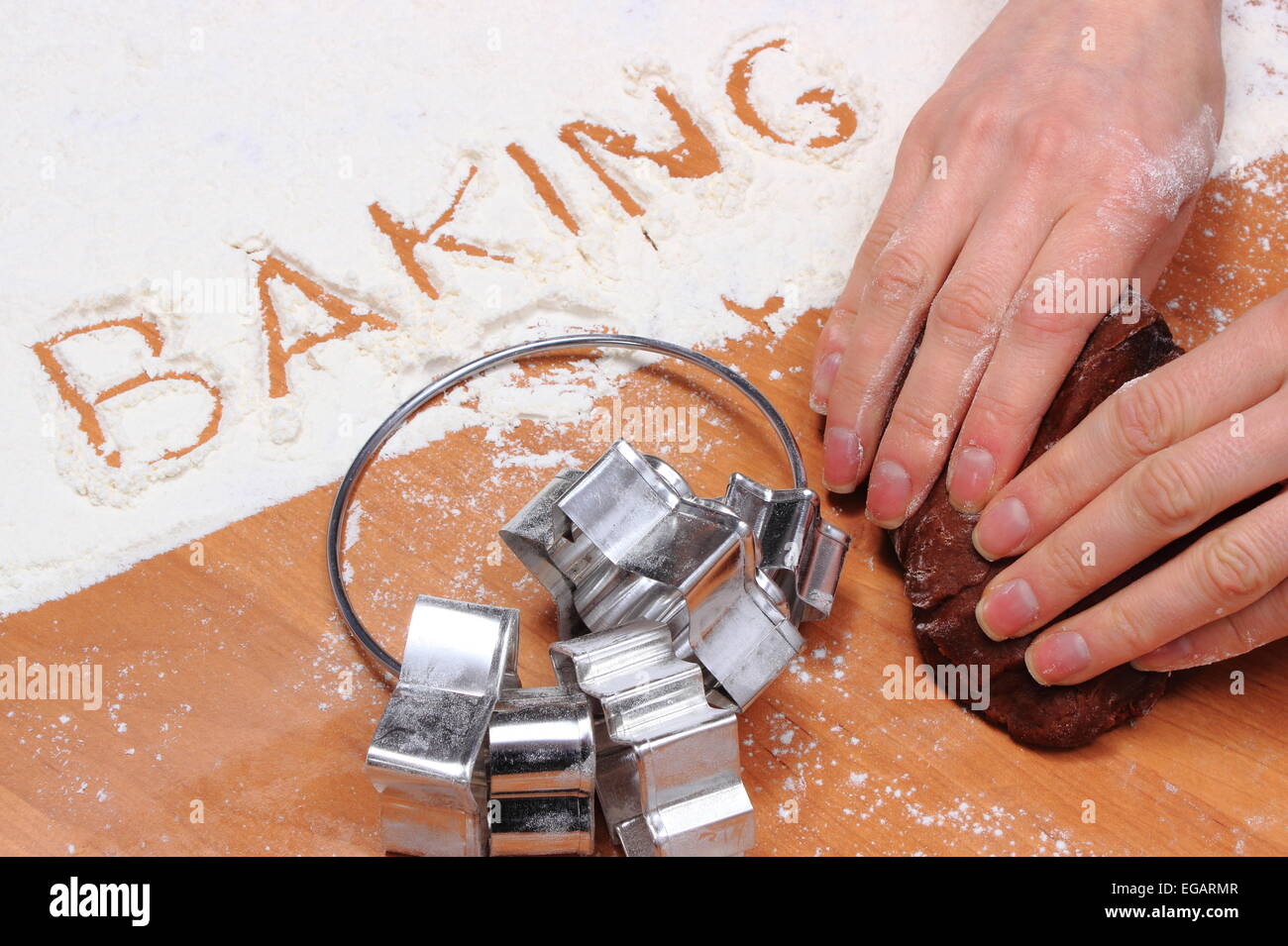 Hand of woman kneading dough for Christmas cookies, word baking in white flour and accessories for baking, concept for baking Stock Photo