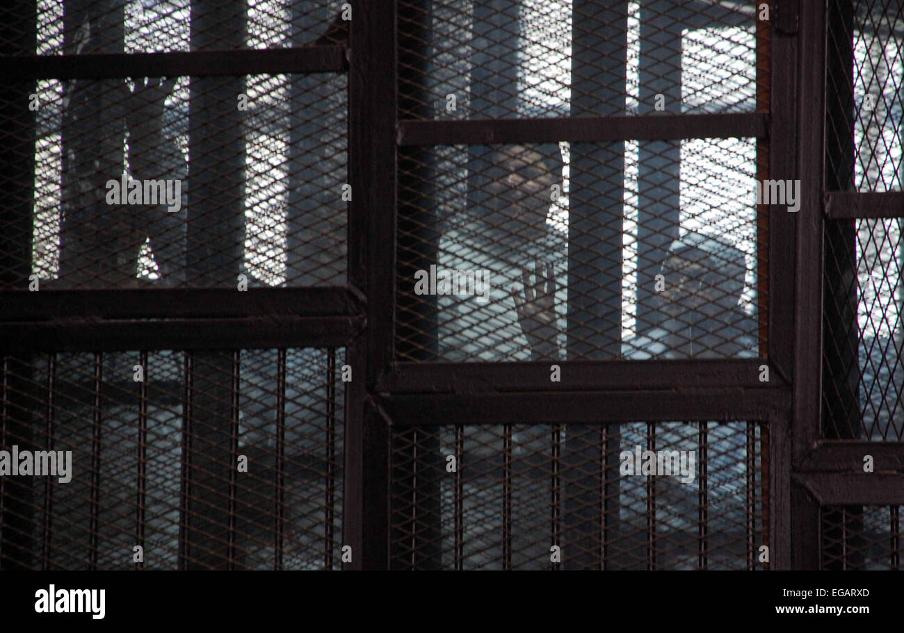 Cairo, Egypt. 21st Feb, 2015. Egyptian defendants are seen behind bars during their trial, in a case known in media as ''Rabaa Operation Room'', in Cairo on February 12, 2015. The prosecution accused the defendants of several charges relating to preparation of an operation room to guide the movement of the Muslim Brotherhood organization in order to confront the state and spread chaos in the country Rabaa and Al Nahda sit-in clearing, and also accused them of plotting to storm and burn police stations, private properties and churches © Stringer/APA Images/ZUMA Wire/Alamy Live News Stock Photo