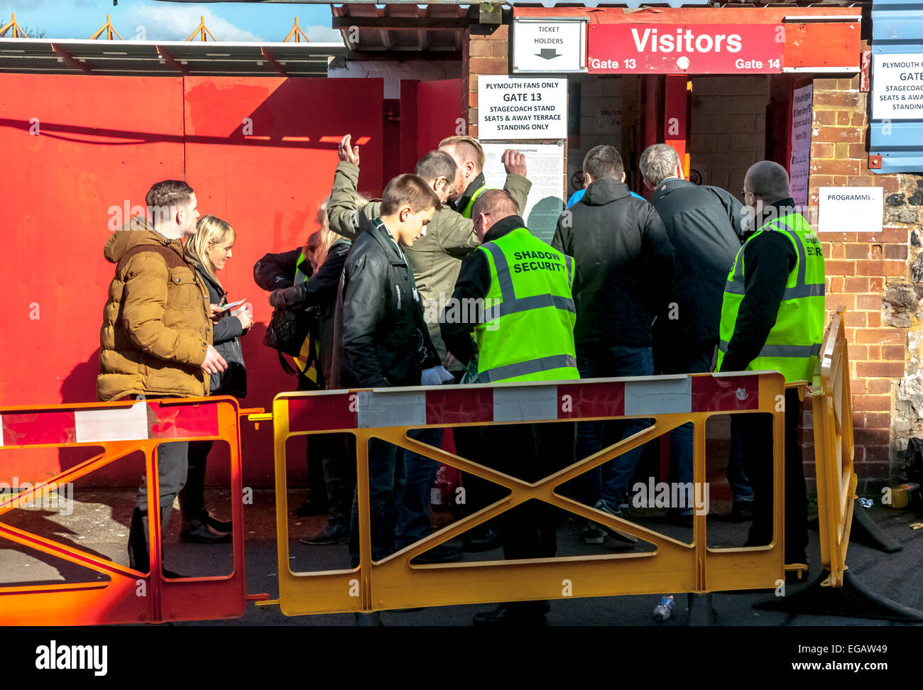 Security guards search Plymouth Argyle football fans as they enter the