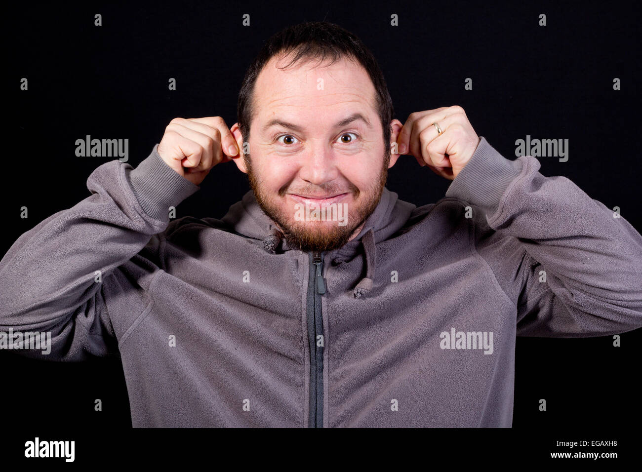 young man making a funny face isolated on black Stock Photo