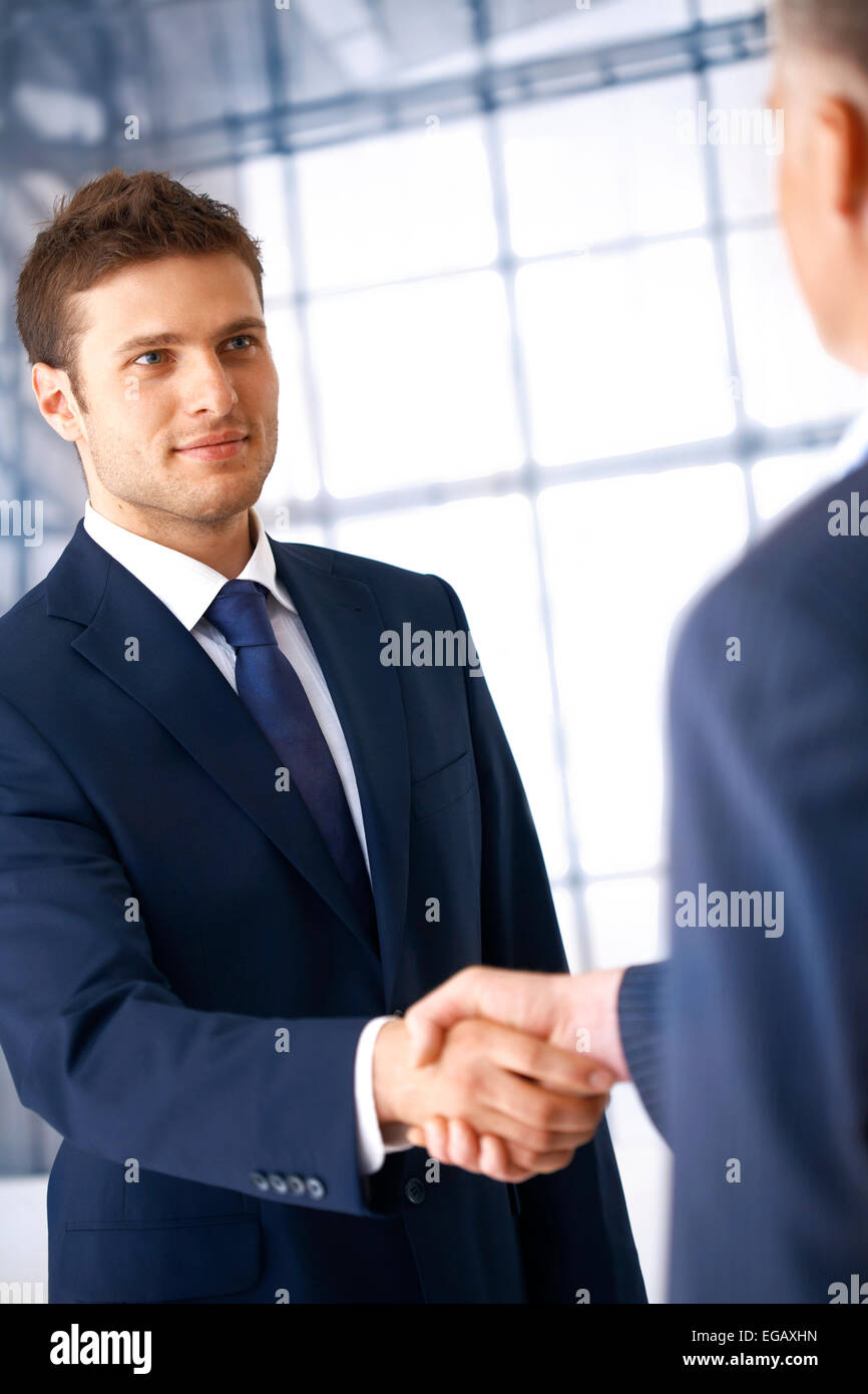 Business people shaking hands, coming to an agreement in the office. Stock Photo