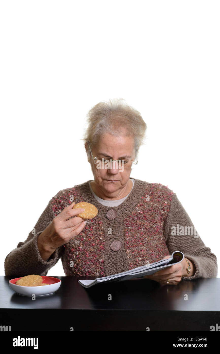 Middle aged woman eating biscuits hires stock photography and images