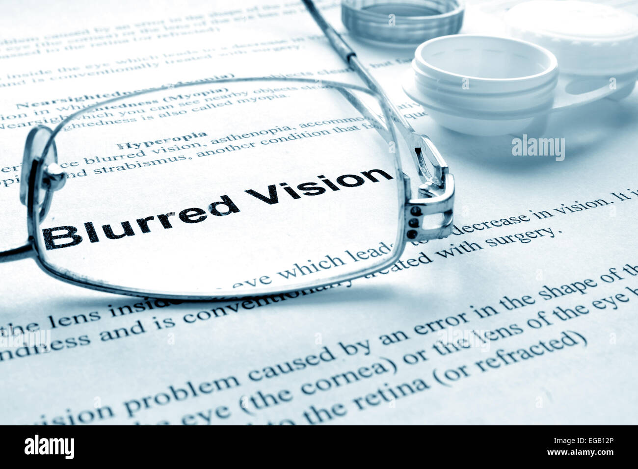 Paper with words  blurred vision, glasses and container for lenses. Eye disorders. Selective focus. Stock Photo