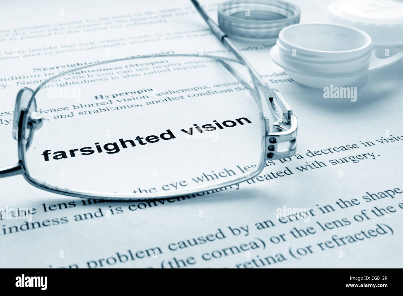 Paper with words  farsighted vision, glasses and container for lenses. Eye disorders. Selective focus. Stock Photo