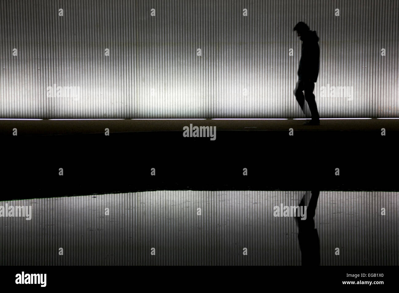 Lonely man walking under a bridge/tunnel Stock Photo