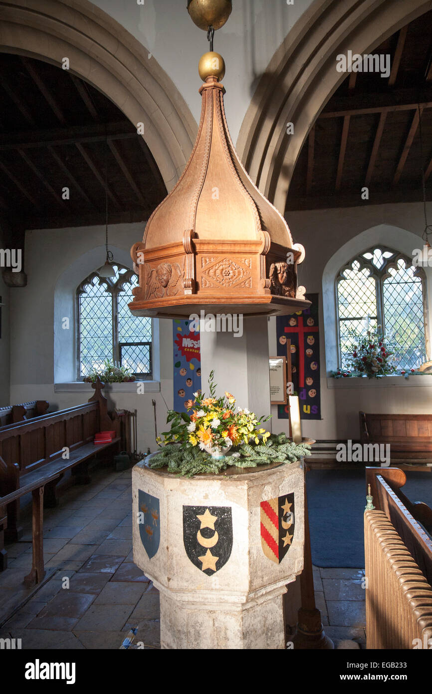 Baptismal font with heraldic shield inside church of Saint Leonard, Horringer, Suffolk, England, UK Stock Photo