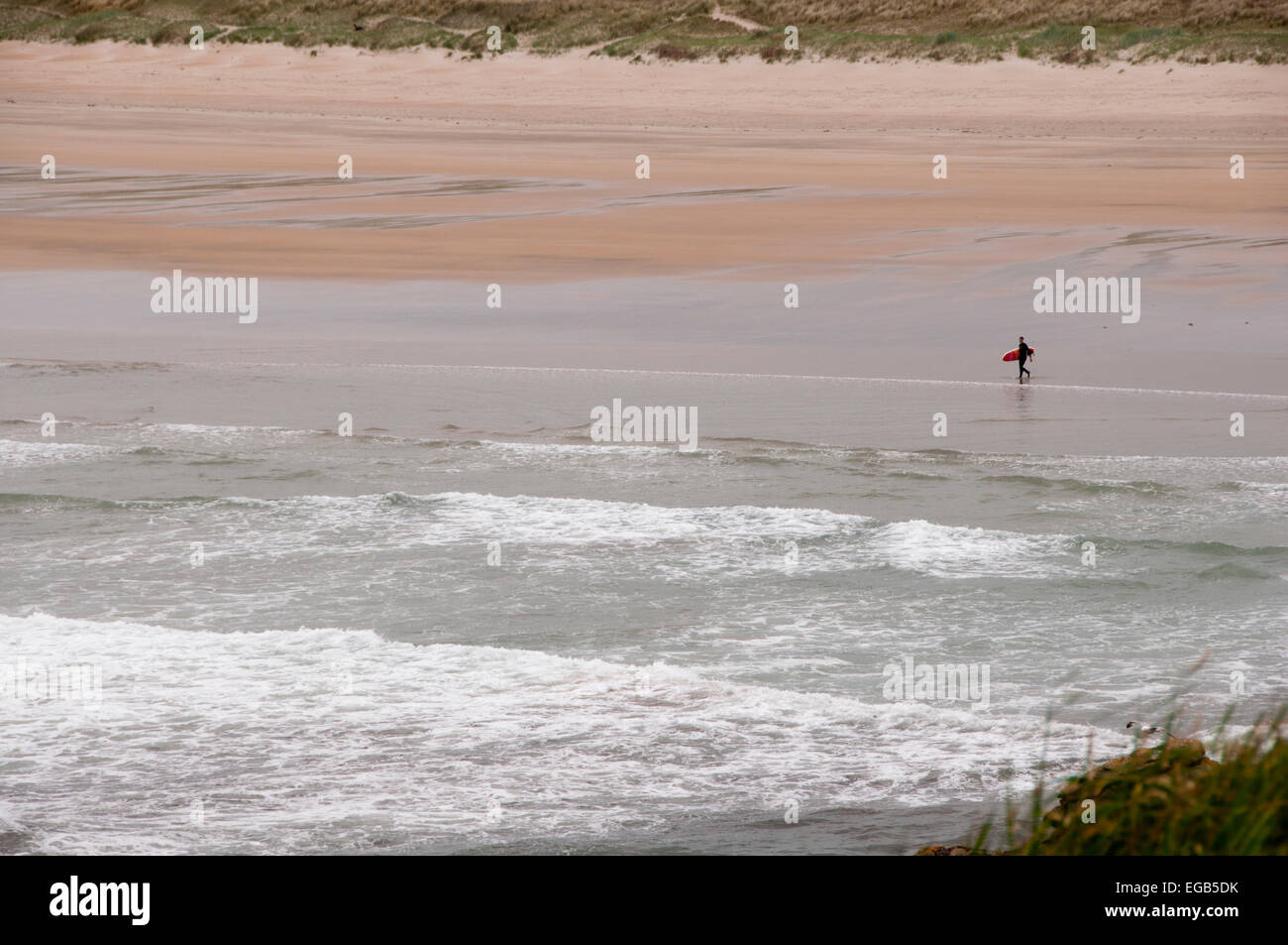 Lone surfer on a beach in Bundoran, Donegal, Ireland Stock Photo