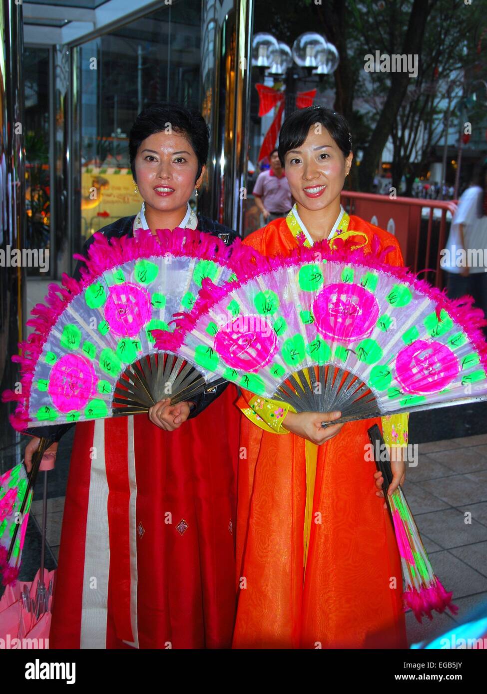 Singapore: Two Korean women on Orchard Road wearing traditional clothing holding colourful open fans   * Stock Photo