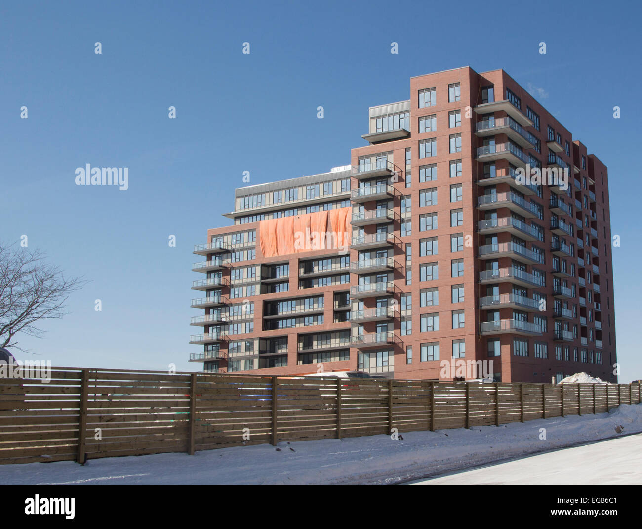Apartment building almost completed with tarps covering apartment with no windows Stock Photo