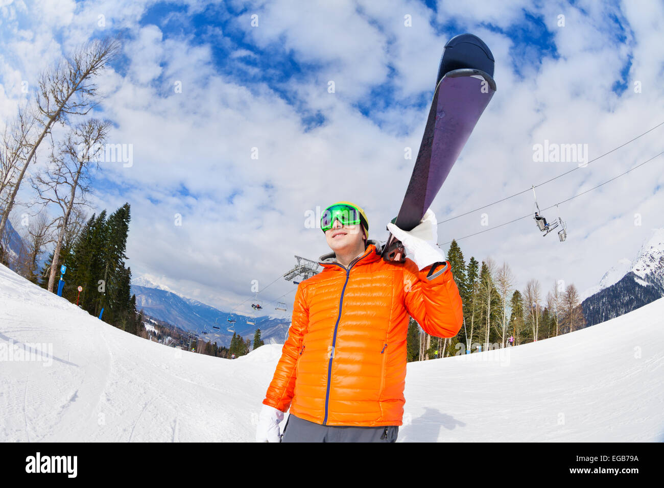 Happy young man wearing mask holds ski in winter Stock Photo