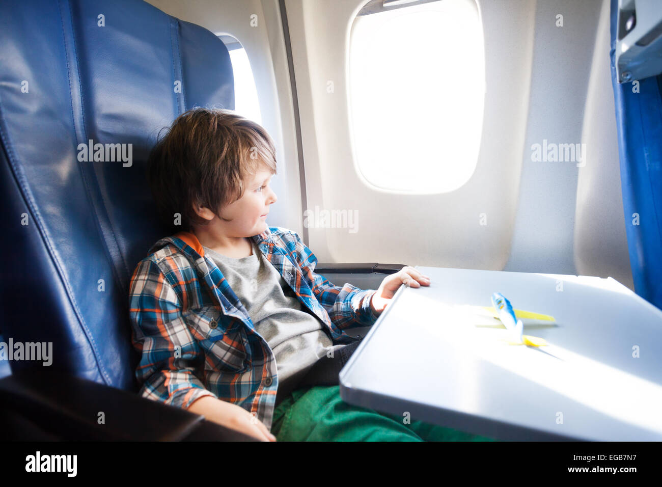 Happy boy sit in plane with toy model on table Stock Photo Alamy