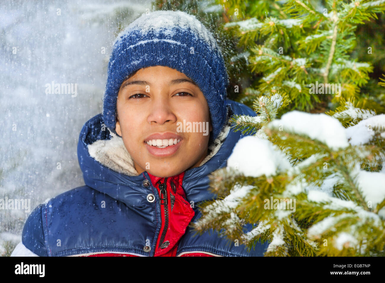 Smiling boy in the forest with snow flakes Stock Photo