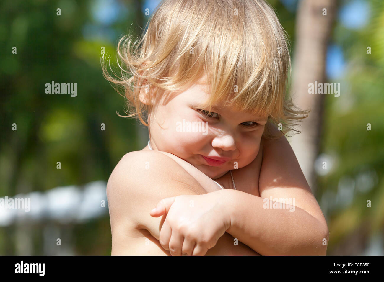 Outdoor closeup portrait of cute shy Caucasian blond baby girl Stock Photo