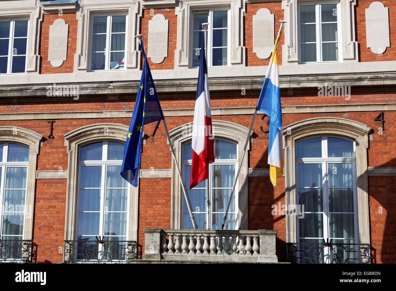 Flags flying outside the Hotel de Ville, in the fortified old town of Boulogne sur Mer Stock Photo