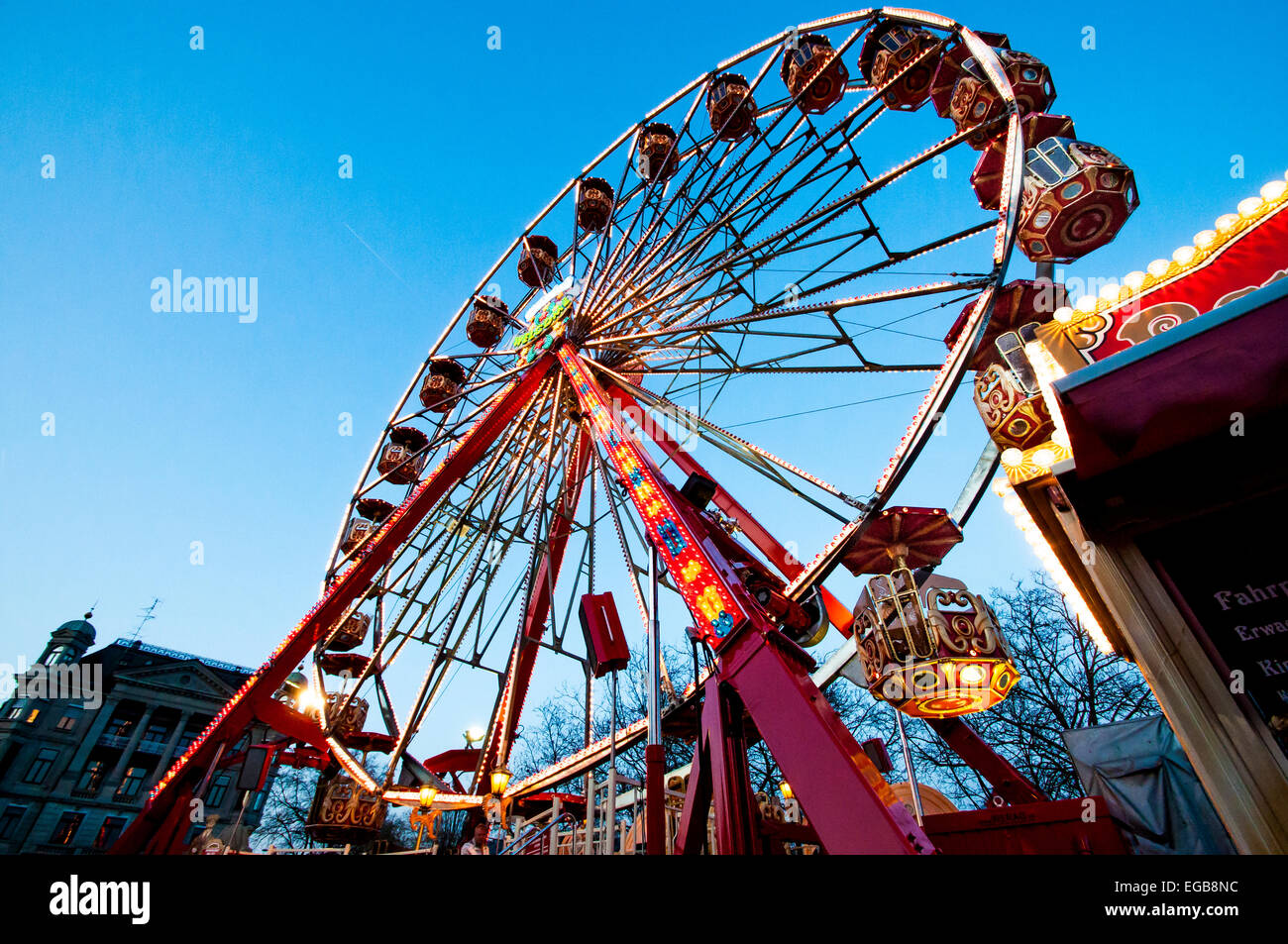 Ferris wheel in Zurich, Switzerland taken at sunset. Annual carnival perched at the mouth of the Limmat Rive and Lake Zurich. Stock Photo