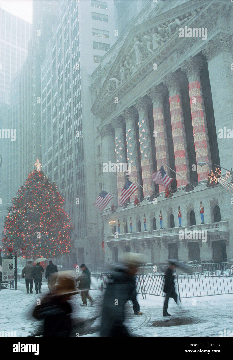 Wall Street workers and visitors pass the New York Stock Exchange