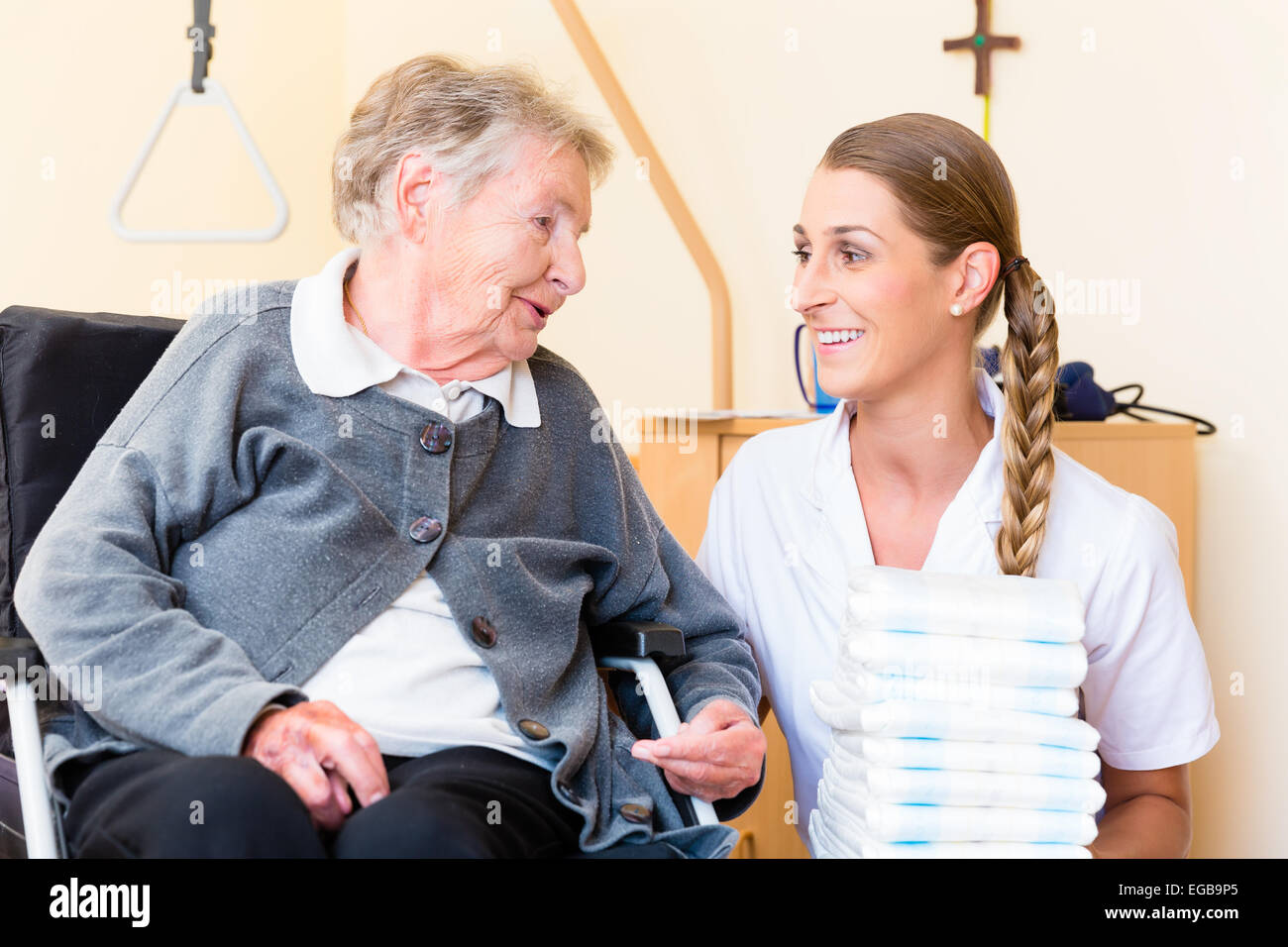 Nurse bringing supplies to senior woman in retirement home Stock Photo