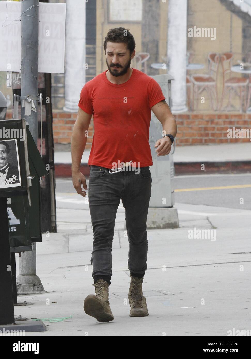 A bearded Shia LaBeouf wearing his favourite old red 'Mighty Alpha  Superstars 1981-1982' t-shirt jumps down from the back of a pickup truck  carrying a Nike holdall and old sneakers Featuring: Shia