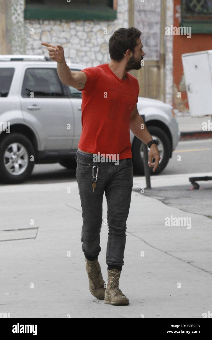 A bearded Shia LaBeouf wearing his favourite old red 'Mighty Alpha  Superstars 1981-1982' t-shirt jumps down from the back of a pickup truck  carrying a Nike holdall and old sneakers Featuring: Shia