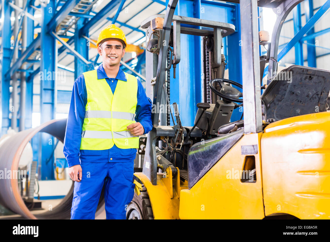 Forklift driver standing proud in manufacturing plant Stock Photo Alamy