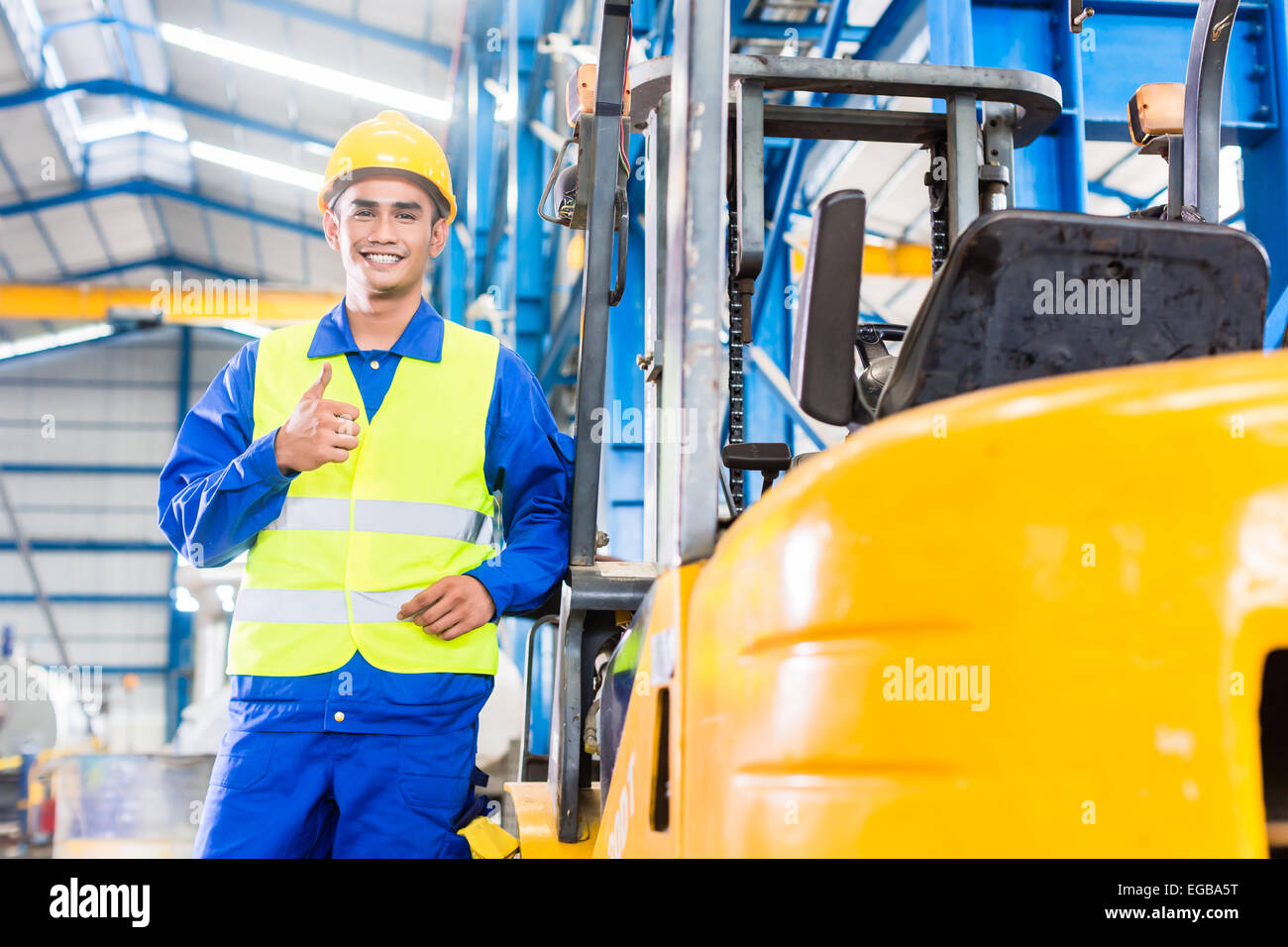 Forklift driver standing proud in manufacturing plant Stock Photo Alamy