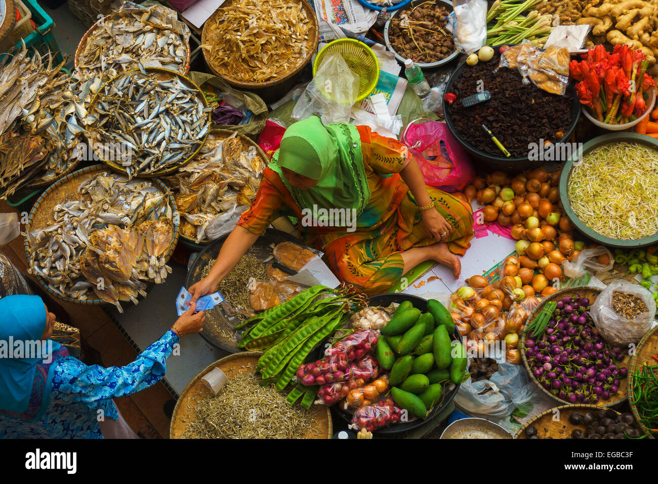 A local seller doing her daily transaction of selling the goods for visitors at Pasar Besar Siti Khadijah. Stock Photo