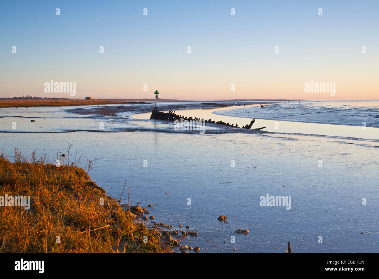Faversham Creek, Kent, UK. 22nd February, 2015. UK weather: A cold and frosty start to Sunday as the clear blue sky reflects over a wreck at low tide along the river bank. The weather in the south east for the week ahead will be a mixture of sunshine and clear skies with some showers at times Stock Photo