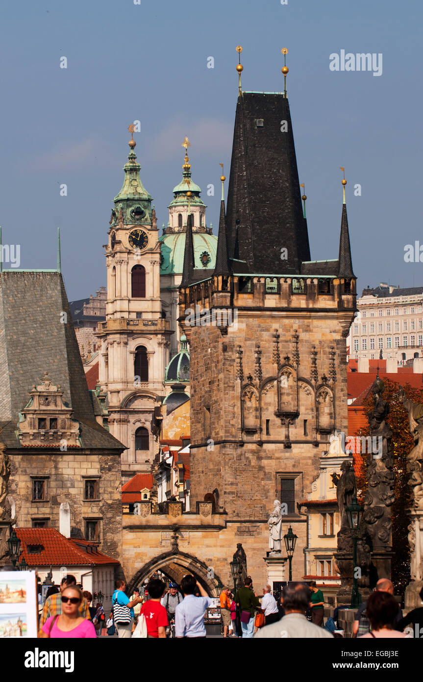 Tourists on Charles Bridge on a sunny day.  St Nicholas Church is in background.  Looking toward Mala Strana. Stock Photo