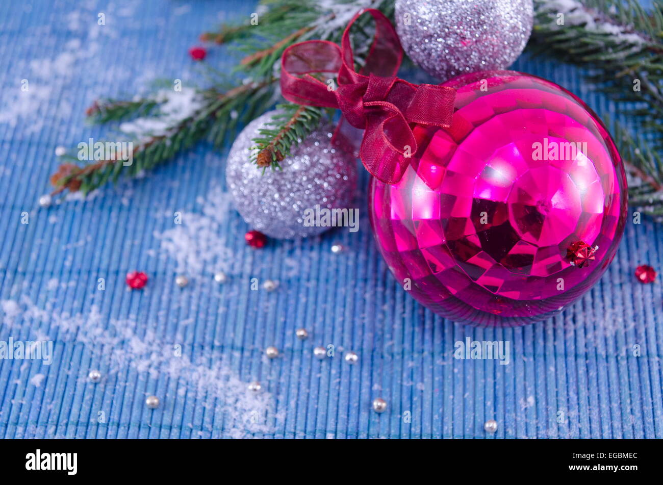 Pink ornament Christmas ball with a fir tree on white table cloth Stock Photo