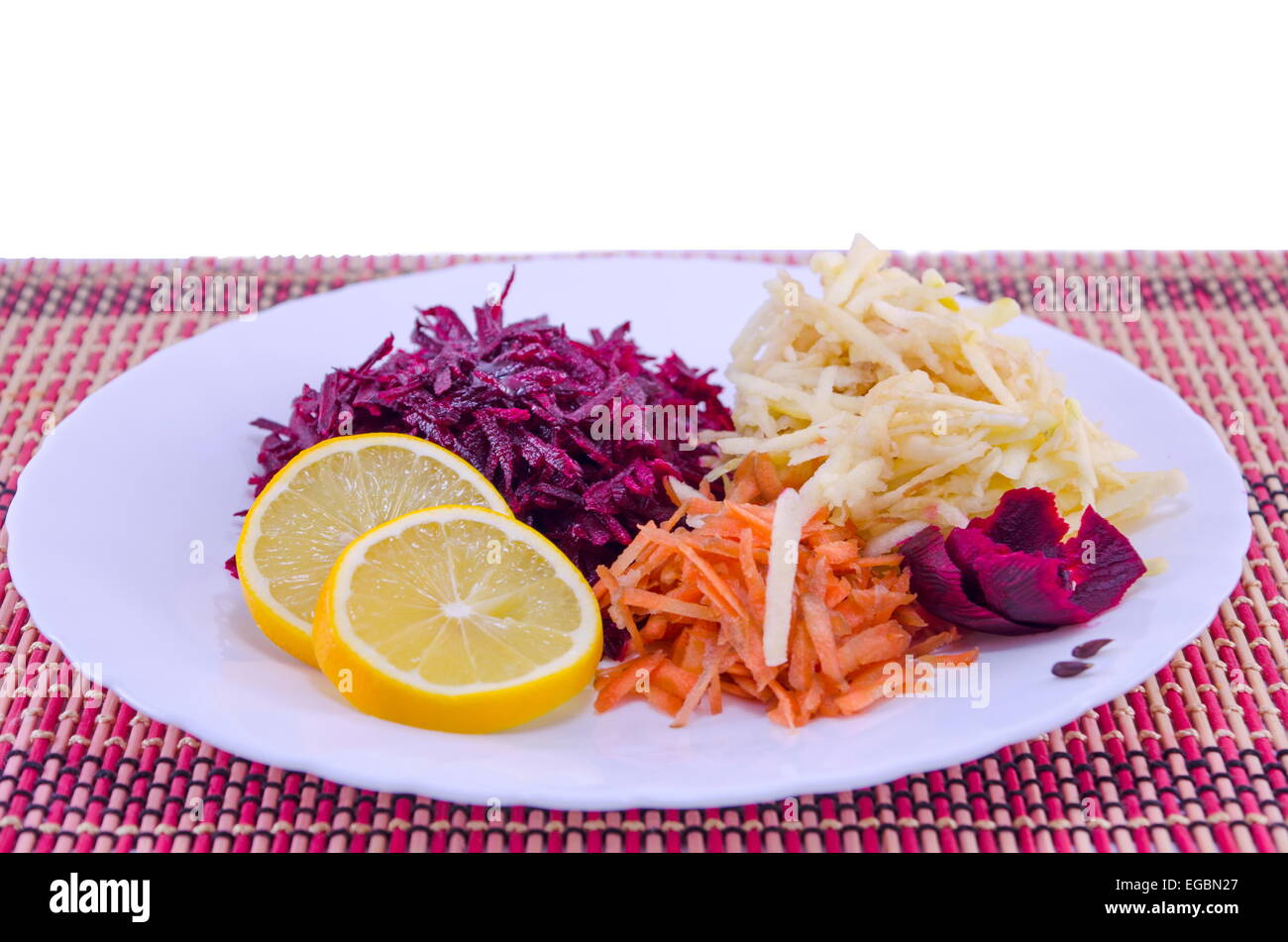 Grated carrots beet and apples on a white plate Stock Photo