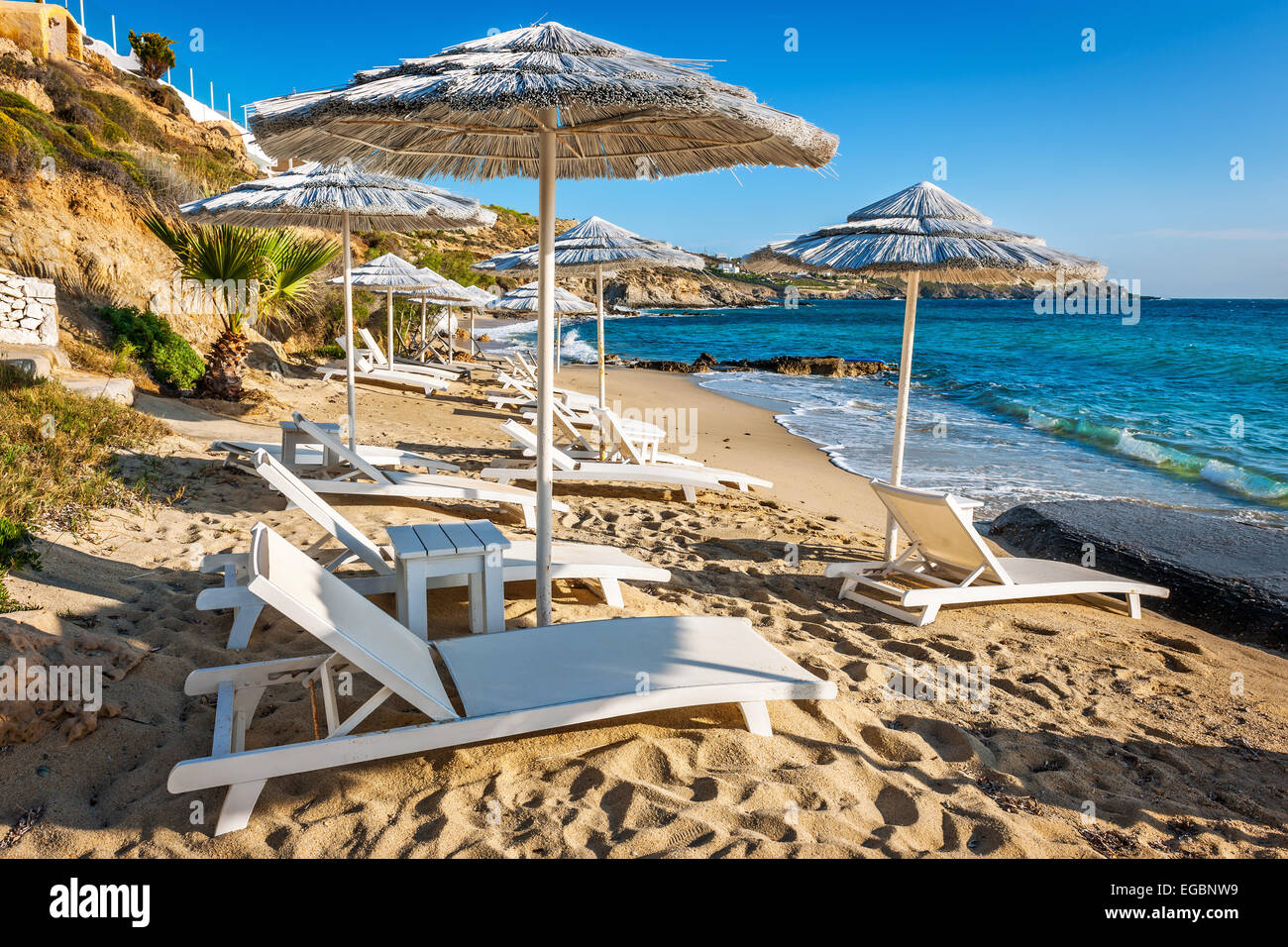 Loungers and parasols on little beach in Mykonos, Greece, Europe Stock Photo