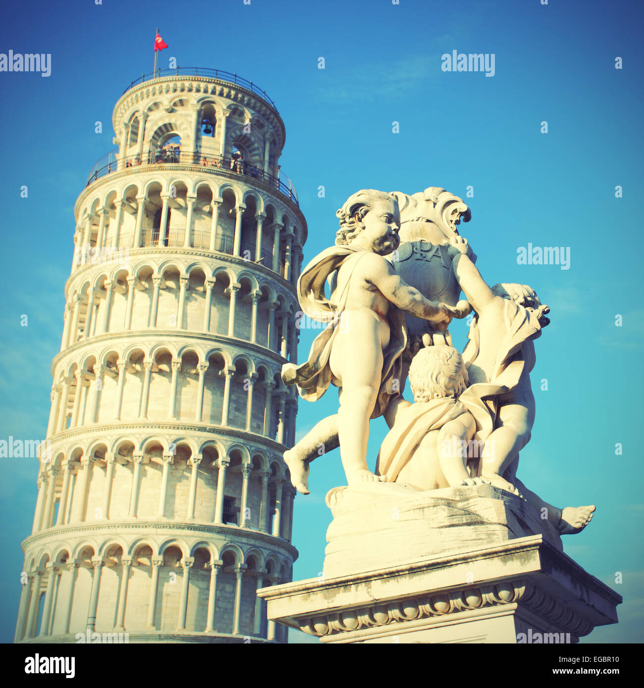 The Leaning Tower of Pisa and La Fontana dei Putti Statue, Italy. Toned image Stock Photo