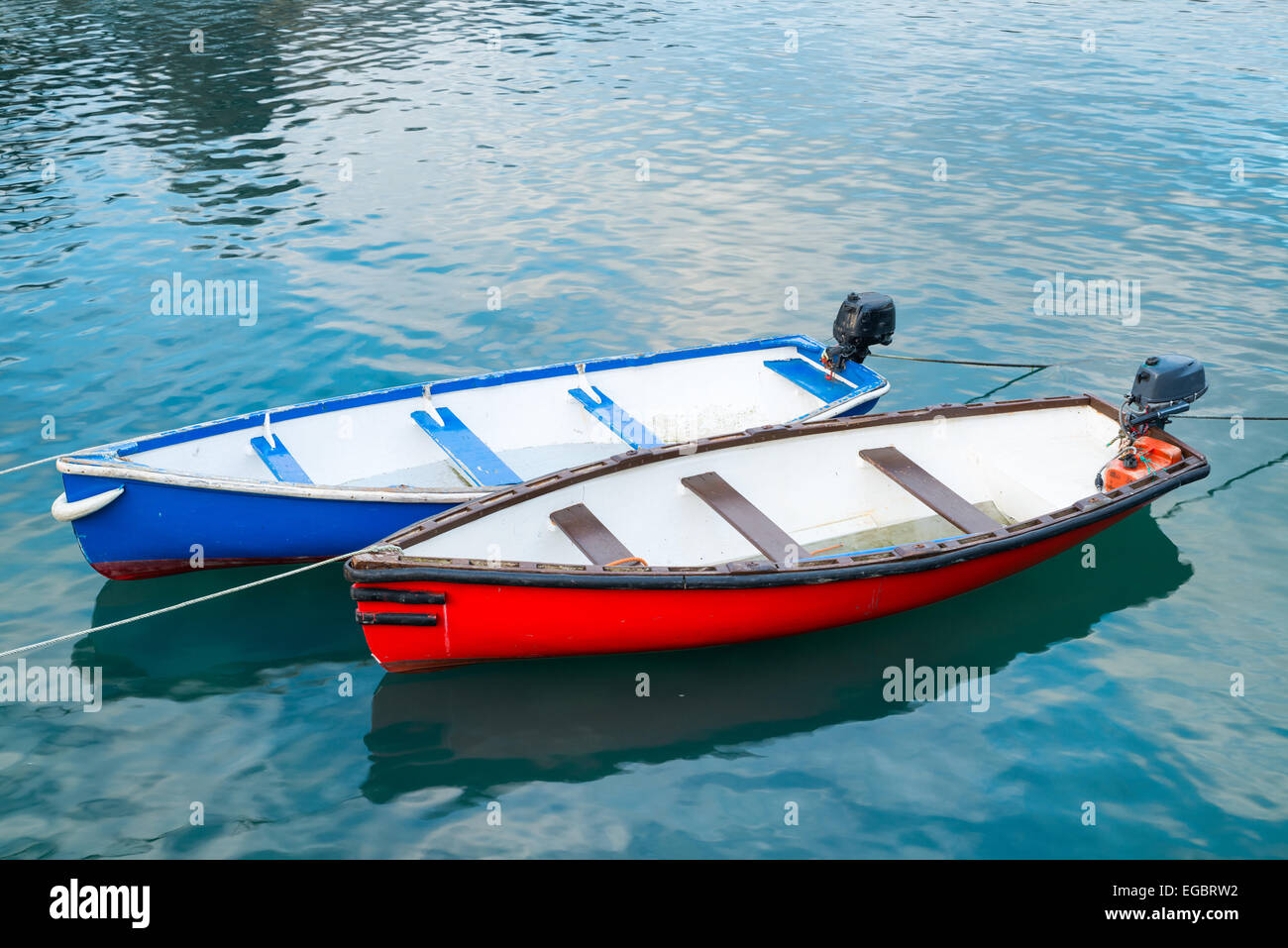 Red and a blue boat moored together Stock Photo