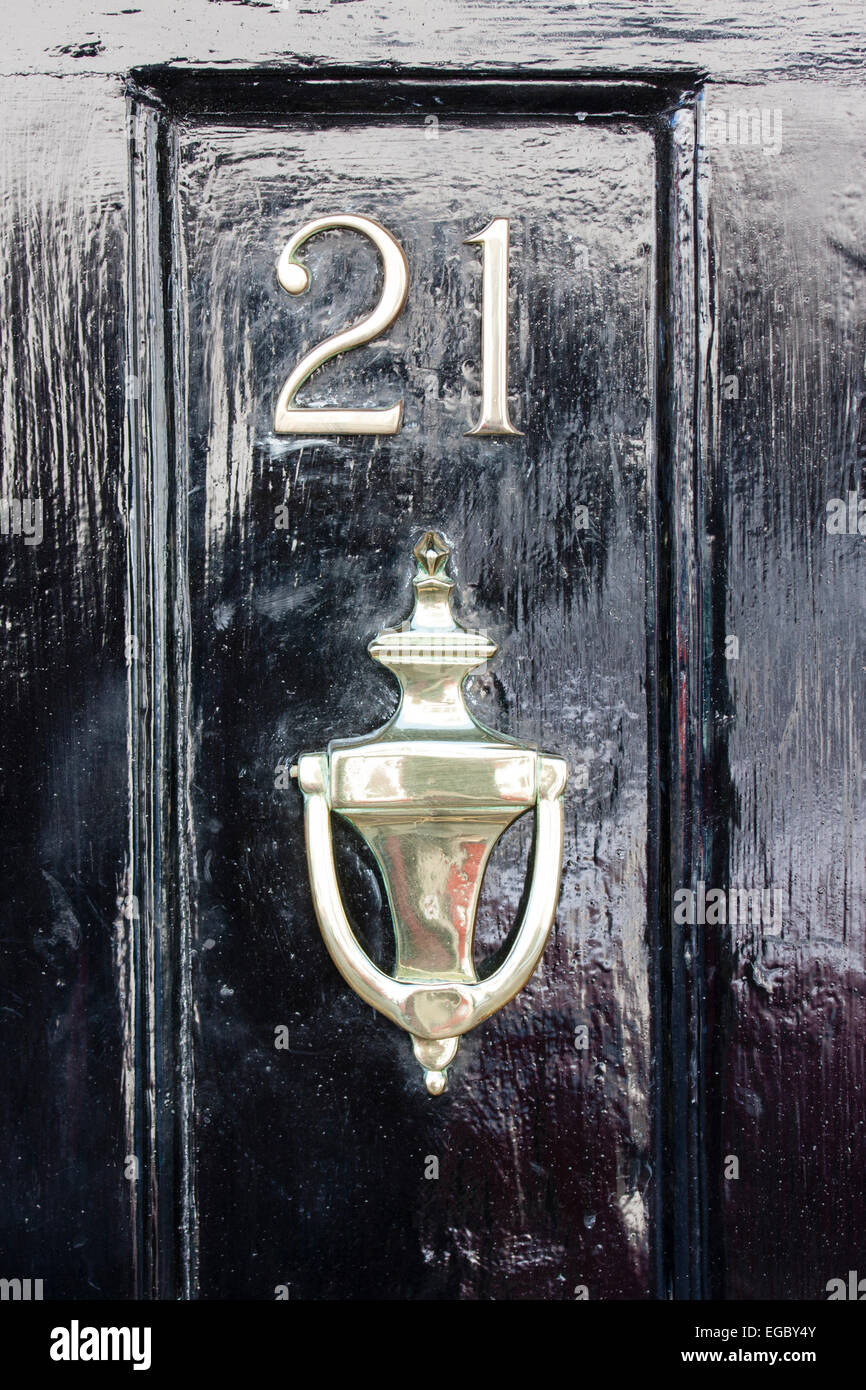 England, Sandwich. Front door, street Number 21 with door knocker underneath. Black wooden door, with number in metal Stock Photo