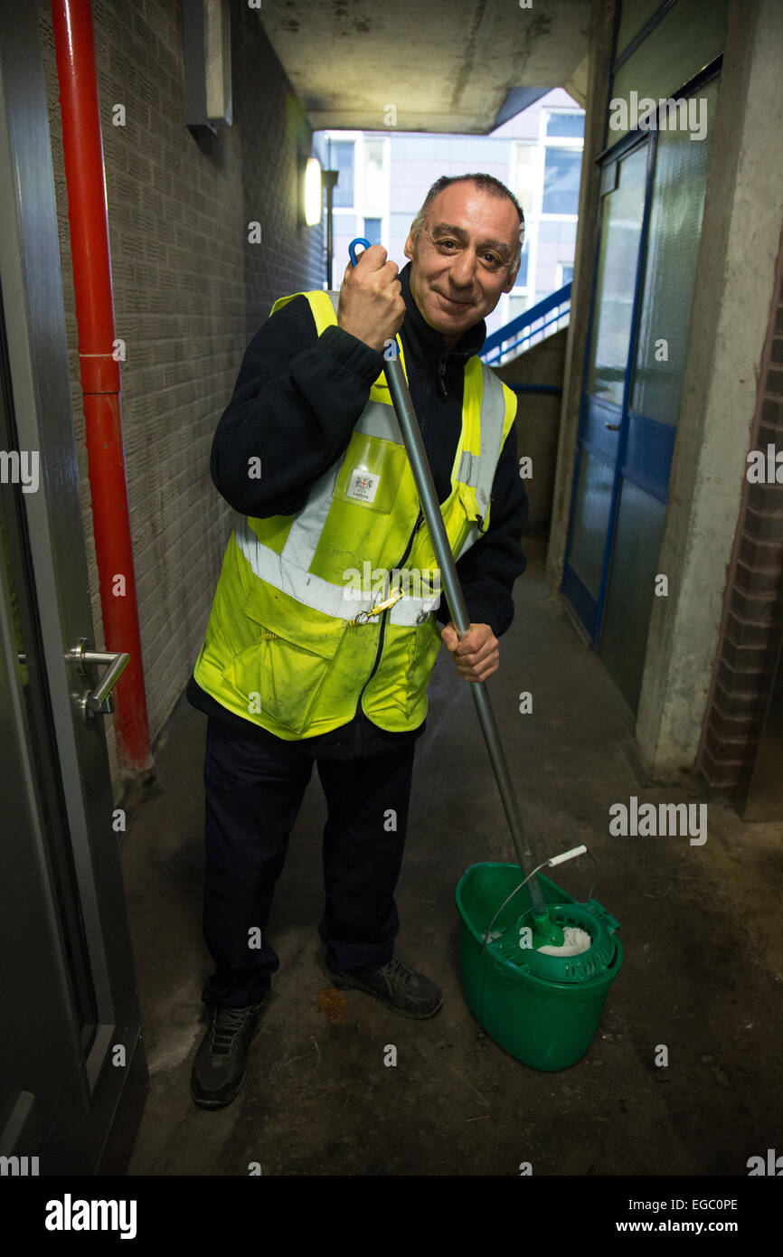 Man mopping the floor of a lift or elevator in a block of London flats Stock Photo