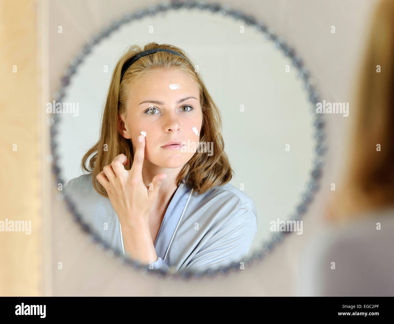 Beautiful young woman applying face cream Stock Photo Alamy